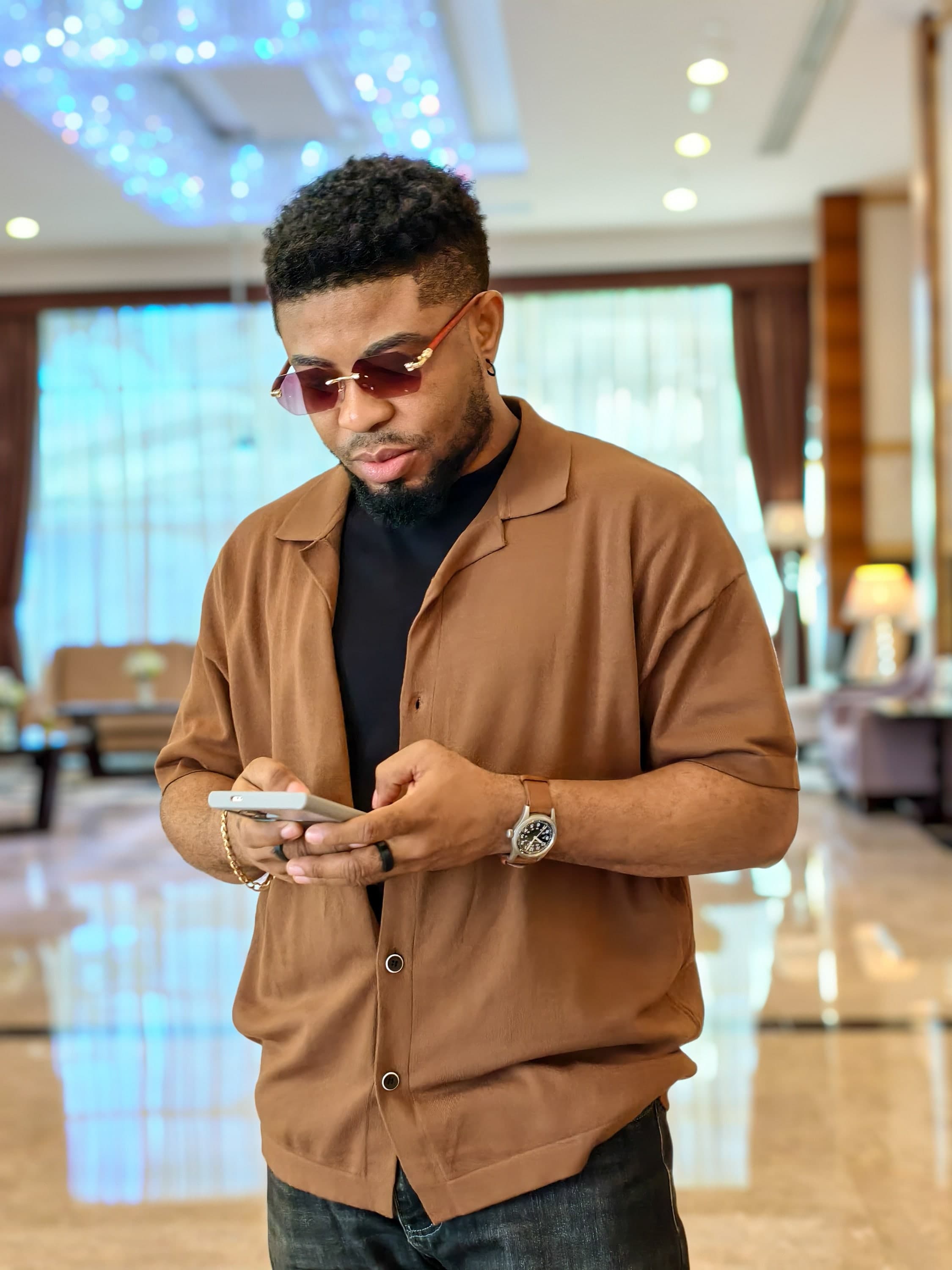 Oscar Frank in a lobby, looking at his phone